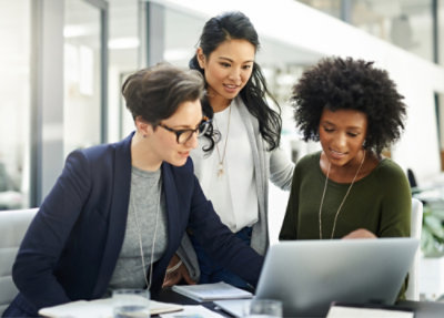 A group of women looking at a laptop.