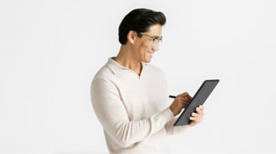 Man sitting and holding Surface Pro 10 in tablet mode