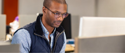 A person with spectacles sitting in a office