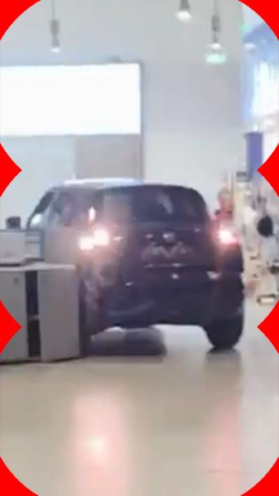 A black car reverses inside a service station, between Costa and WH Smith