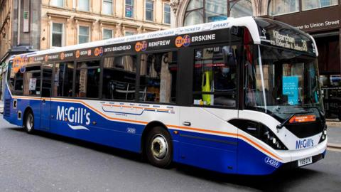 A blue and white single-decker McGill's bus driving on Union Street in Glasgow