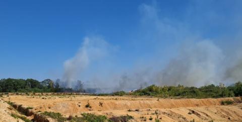 Heathland fire in Blackwater, Camberley - smoke is seen coming from shrubs and trees 