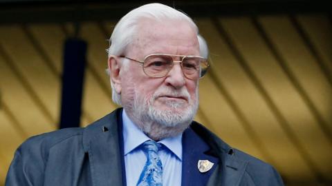 Former Chelsea and Leeds United owner Ken Bates in light blue shirt and tie, with a Chelsea club badge on his jacket