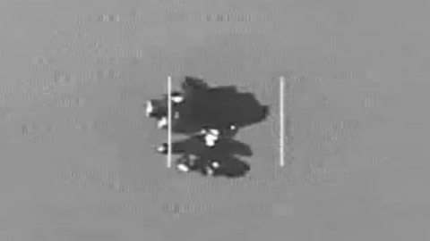 An object which is thought to be an Unidentified Anomalous Phenomena in the center of the frame. The image is in black and white and is grainy.