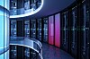 3D illustration of a modern data center with illuminated server racks and curved balcony walkways.