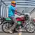 A man sits on an electric motorcycle on a bridge in Kenya